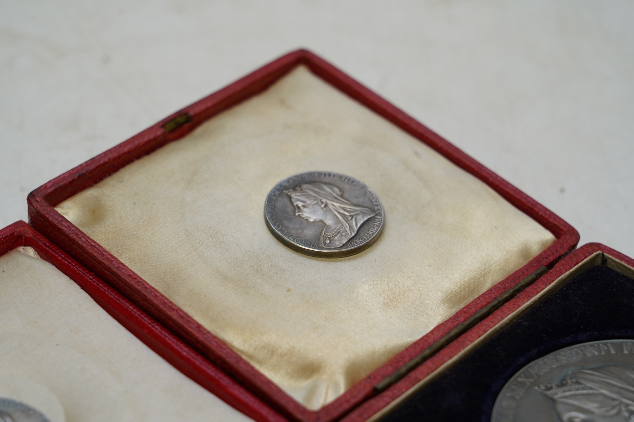 Two Victoria 1897 Diamond Jubilee commemorative silver medals, cased, and two smaller silver medals. Condition - fair